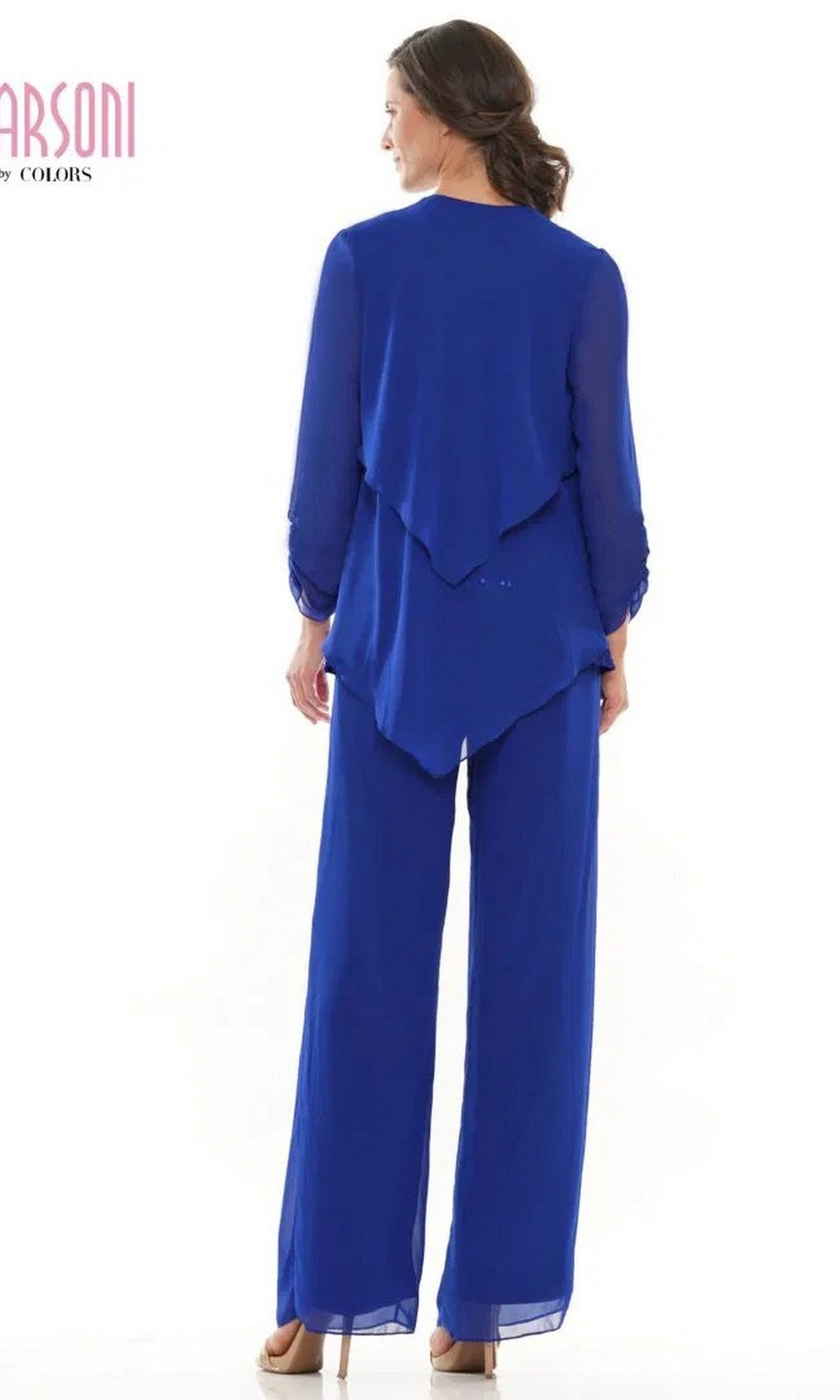 A woman faces away, wearing the Marsoni M303 Long Formal Pantsuit in royal blue, featuring an asymmetrical hem, matching wide-leg pants, and a flowing chiffon jacket.